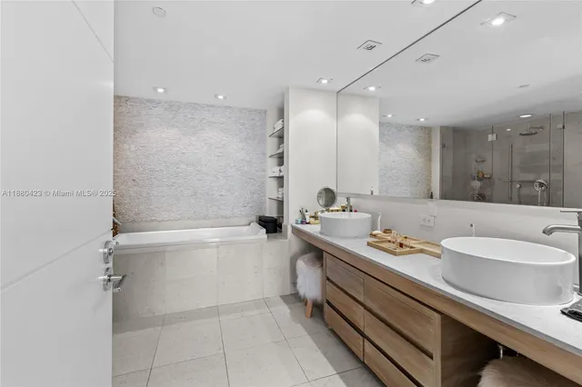 a bathroom with a tub sink and mirror