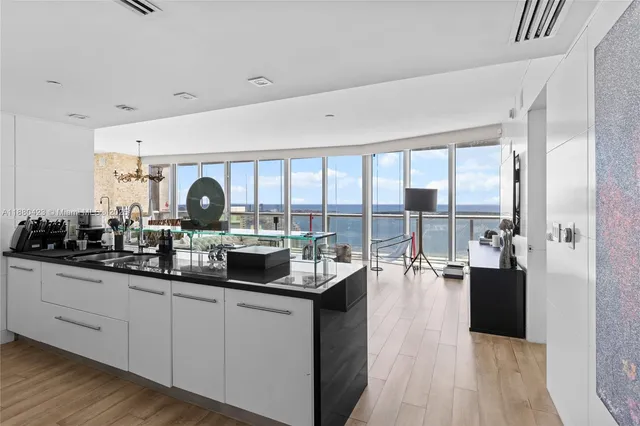 a very nice looking living room with a large window and kitchen view