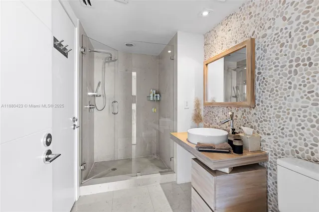 a bathroom with a sink a toilet and shower