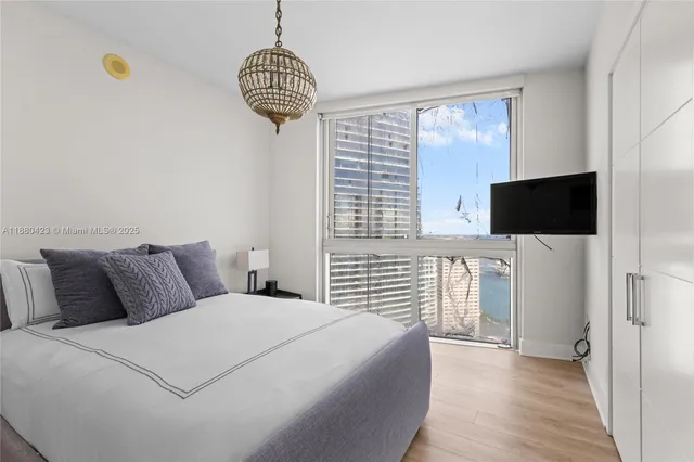 a bedroom with bed tv and window