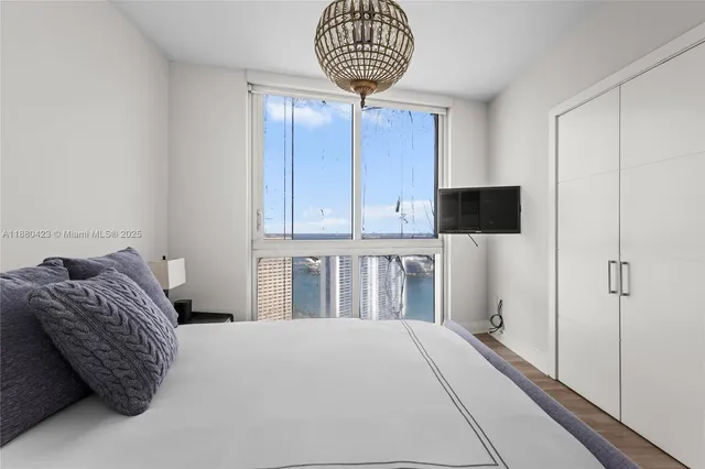 a bedroom with a bed and a chandelier