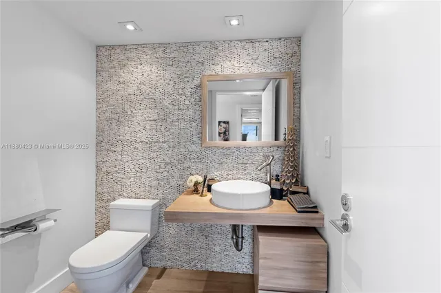 a bathroom with a toilet a sink and mirror