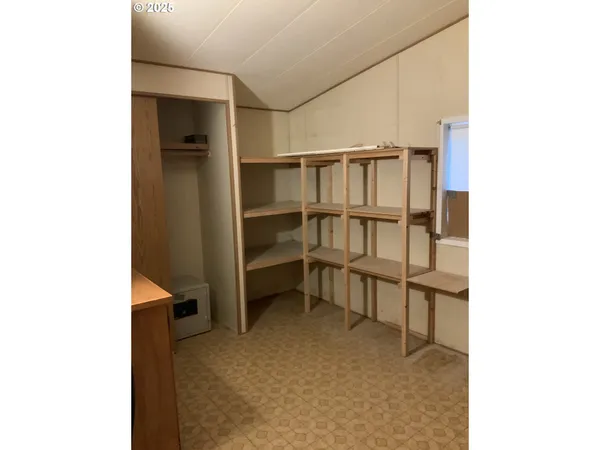 a view of an empty room and kitchen