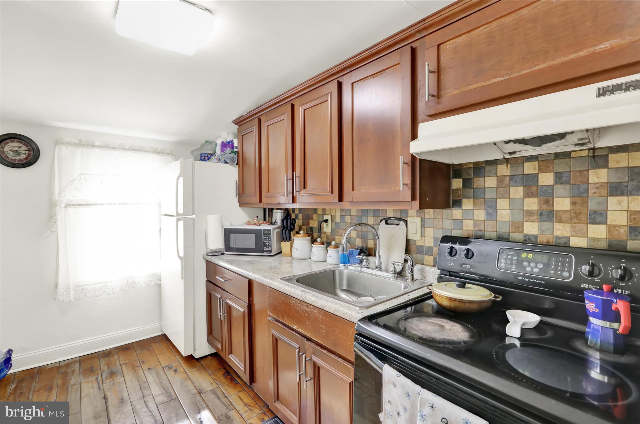 1328 Kenny Street Reading, PA 19602 - Photo 9 of 18 a kitchen with stainless steel appliances granite countertop a sink stove and cabinets