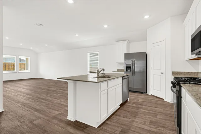 a kitchen with stainless steel appliances granite countertop a stove a microwave and oven