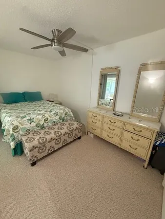 a bedroom with a bed and a ceiling fan