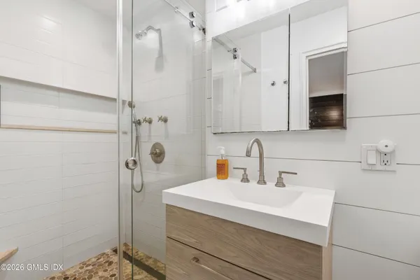 a bathroom with a sink a shower and a mirror