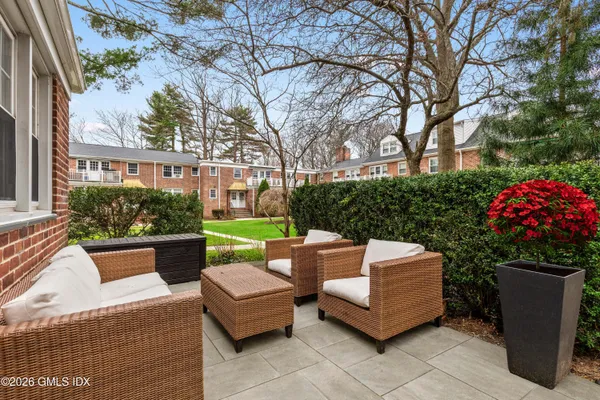 a view of a patio with couches and a fire pit and a barbeque grill with a small yard