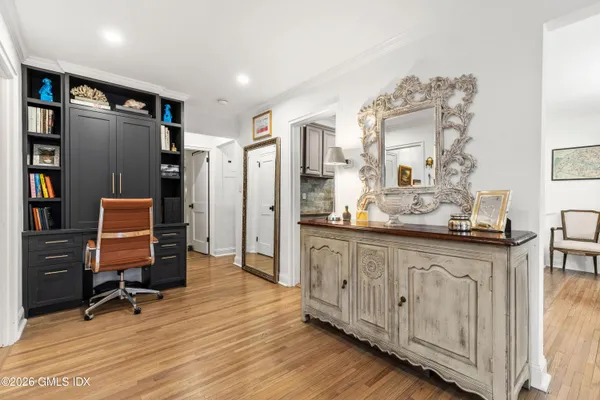 a room with stainless steel appliances kitchen island granite countertop a refrigerator and a wooden cabinets