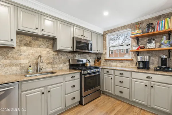 a kitchen with stainless steel appliances granite countertop a sink a stove a microwave and cabinets