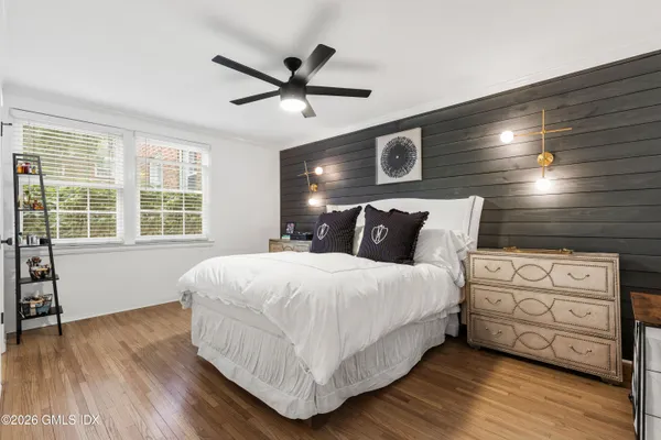 a bedroom with a bed and wooden floor