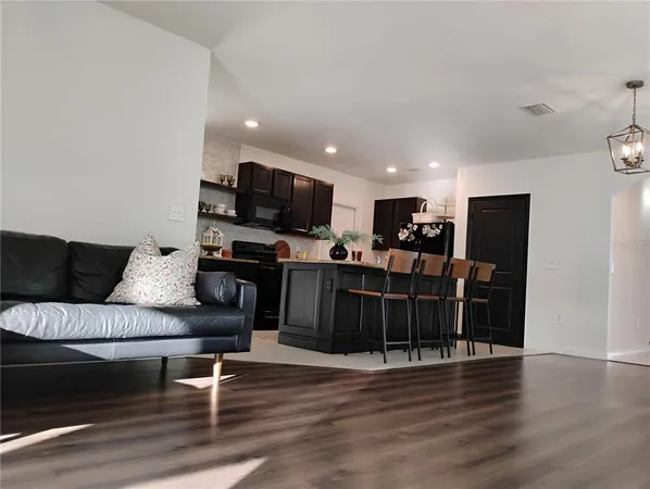 a living room with furniture a flat screen tv and wooden floor