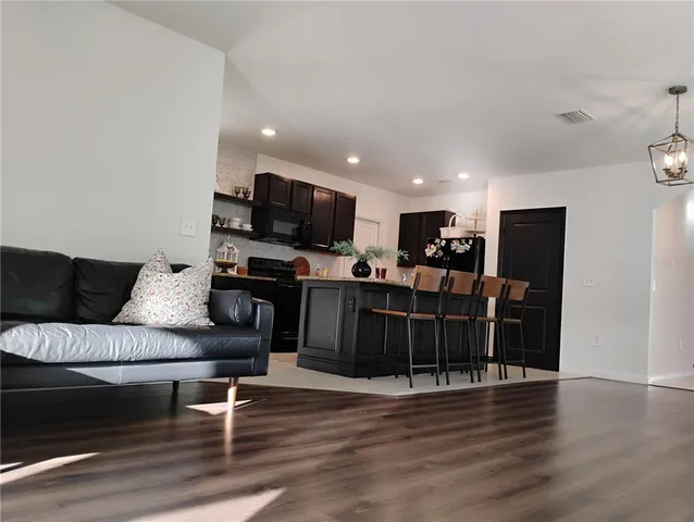 a living room with furniture a flat screen tv and wooden floor