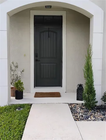 a white house with potted plants in front of door