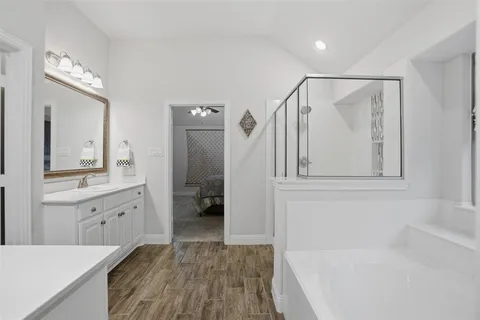 a spacious bathroom with a granite countertop sink a mirror a shower and a bathtub
