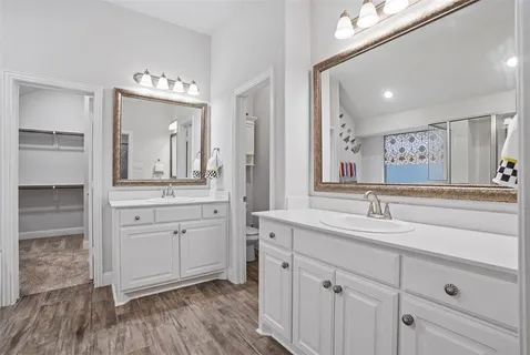 a spacious bathroom with a double vanity sink and a mirror