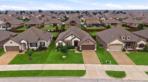 an aerial view of multiple houses with a yard