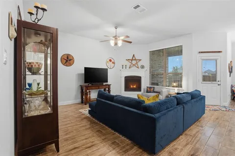 a living room with furniture a flat screen tv and a fireplace