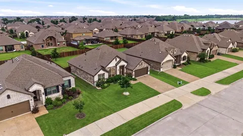 an aerial view of multiple houses with a yard