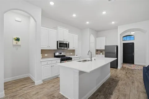 a kitchen with stainless steel appliances a sink stove and refrigerator