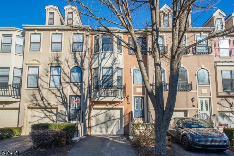 a view of a blue house with large trees