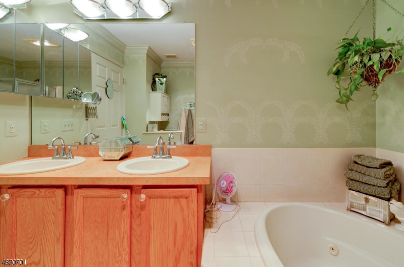 404 Manchester Drive Nutley, NJ 07110 - Photo 16 of 26 a bathroom with a tub sink and mirror