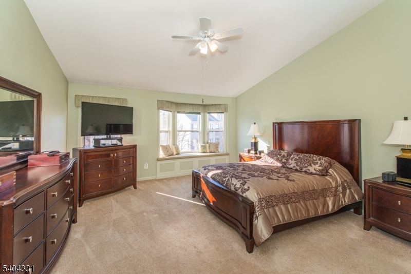 404 Manchester Drive Nutley, NJ 07110 - Photo 26 of 26 a spacious bedroom with a bed a dresser and a chandelier