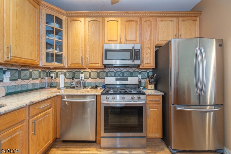 404 Manchester Drive Nutley, NJ 07110 - Photo 6 of 26 a kitchen with stainless steel appliances granite countertop a refrigerator stove and sink
