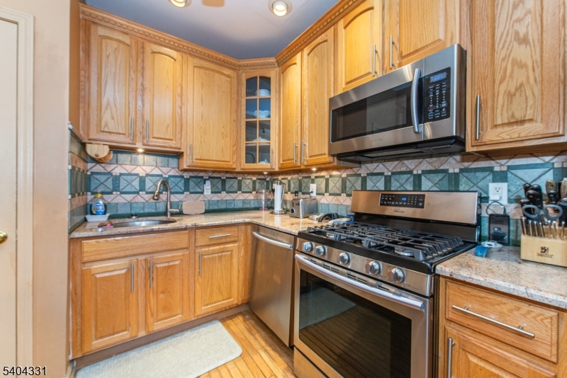 404 Manchester Drive Nutley, NJ 07110 - Photo 7 of 26 a kitchen with stainless steel appliances granite countertop a stove microwave and sink
