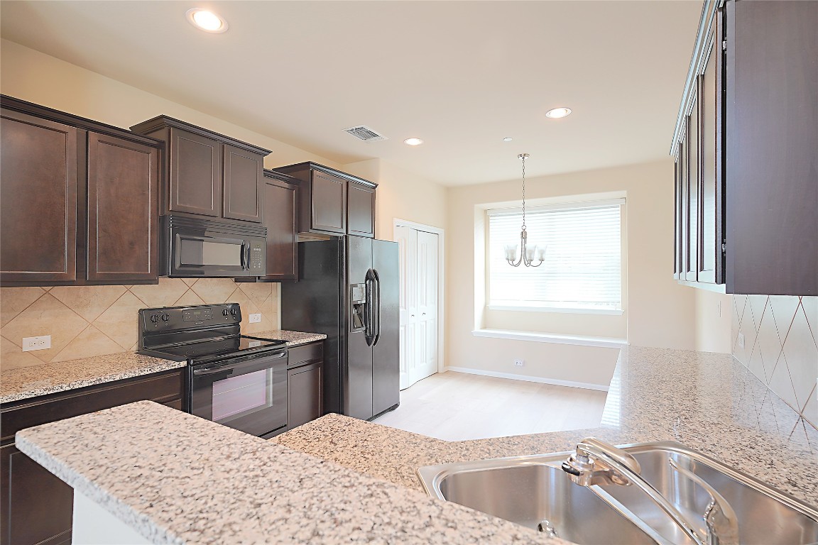 516 East Slaughter Lane, Unit 801 Austin, TX 78744 - Photo 4 of 16 a kitchen with stainless steel appliances granite countertop a sink stove and refrigerator