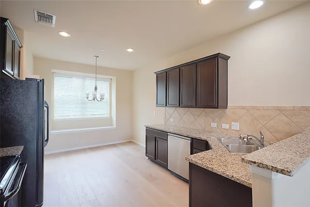 a kitchen with stainless steel appliances granite countertop a sink stove and refrigerator