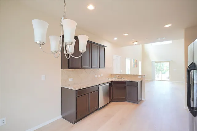 a kitchen with stainless steel appliances granite countertop a sink and a refrigerator