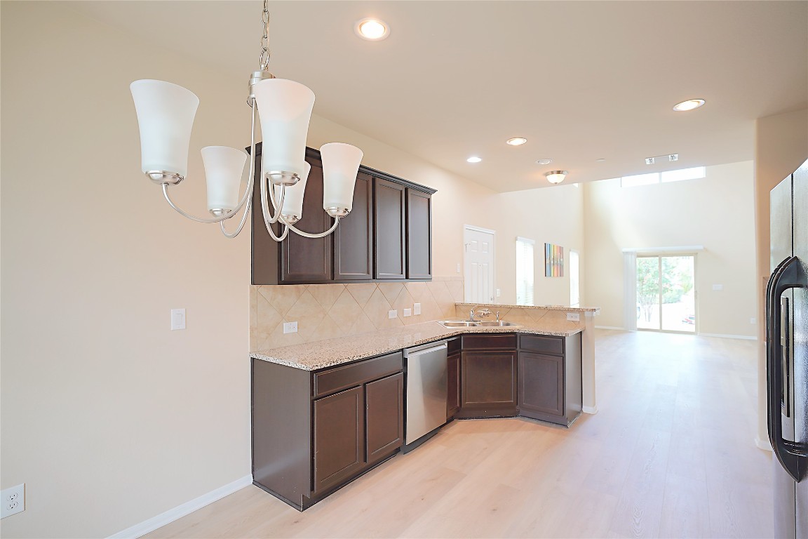 516 East Slaughter Lane, Unit 801 Austin, TX 78744 - Photo 6 of 16 a kitchen with stainless steel appliances granite countertop a sink and a refrigerator