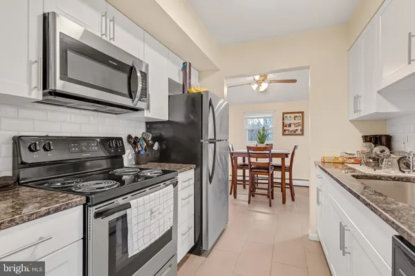 a kitchen with a stove cabinets and microwave