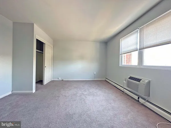 an empty room with windows and closet