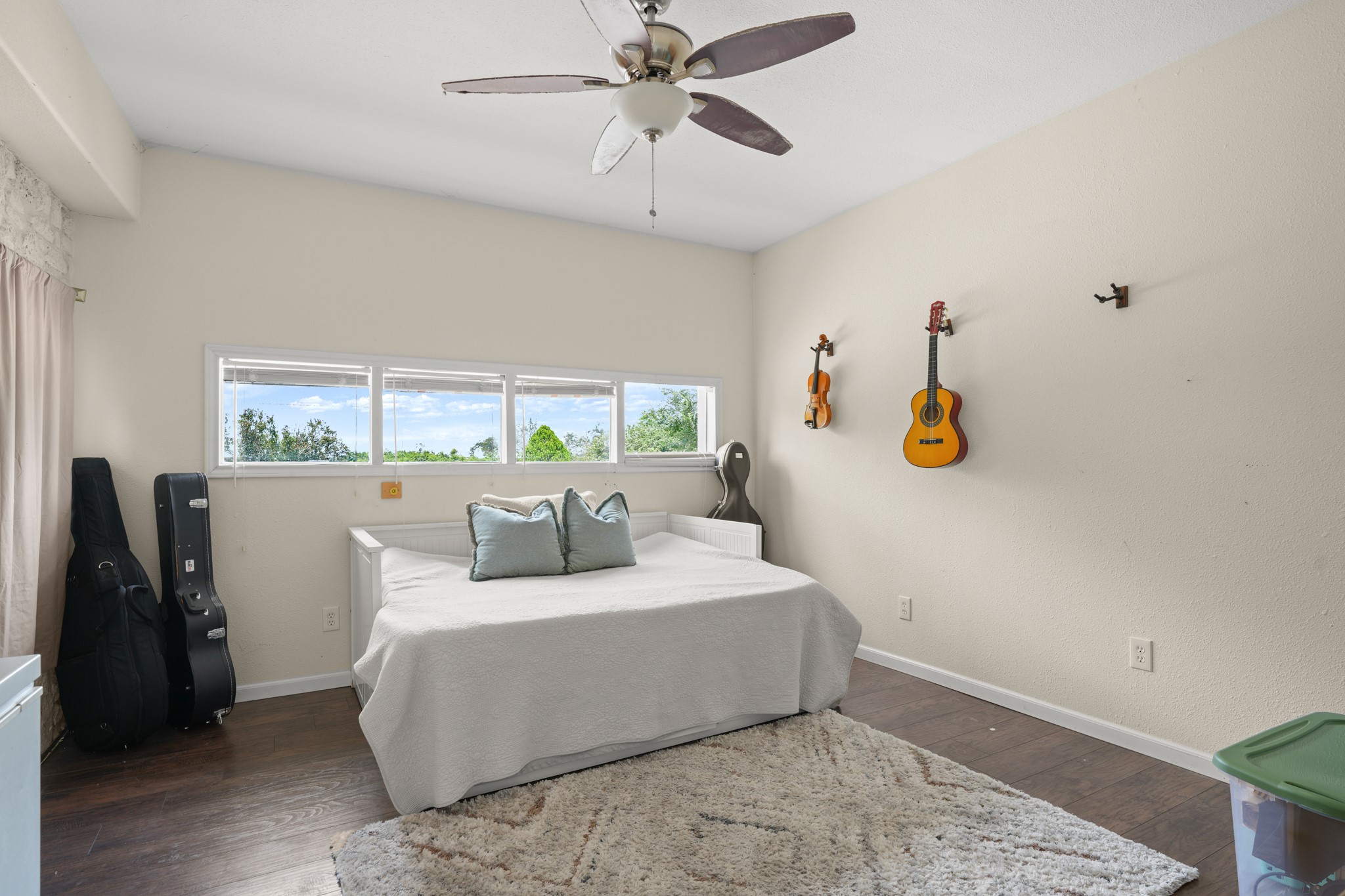 9725 Bock Road Buda, TX 78610 - Photo 13 of 32 A restful room featuring dark hardwood floors and a multi-pane window framing distant trees.
