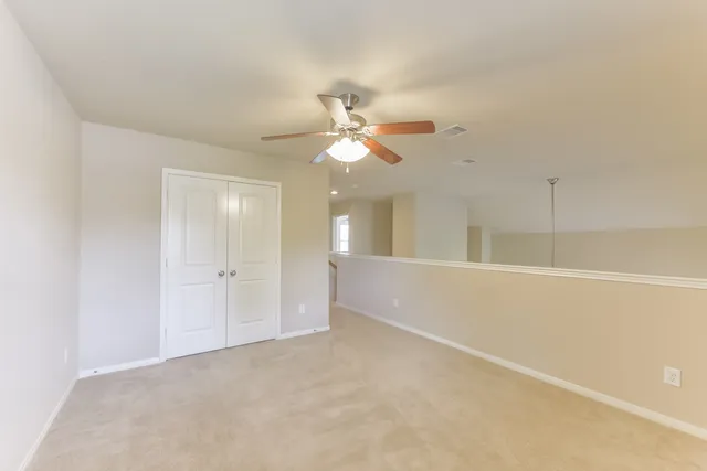 an empty room with fan and a ceiling fan
