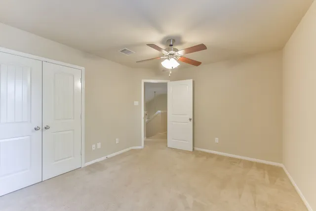 an empty room with a ceiling fan and a window
