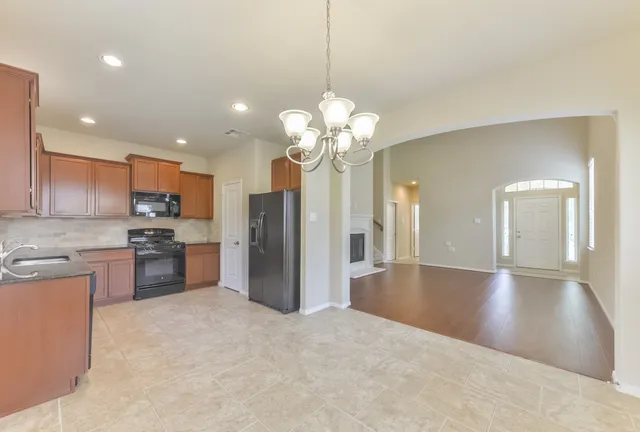 a view of a kitchen with a sink a refrigerator and a stove top oven