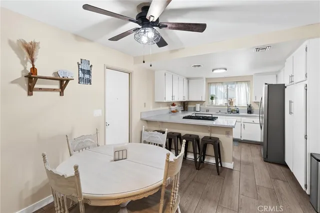 a kitchen with a dining table chairs and white appliances