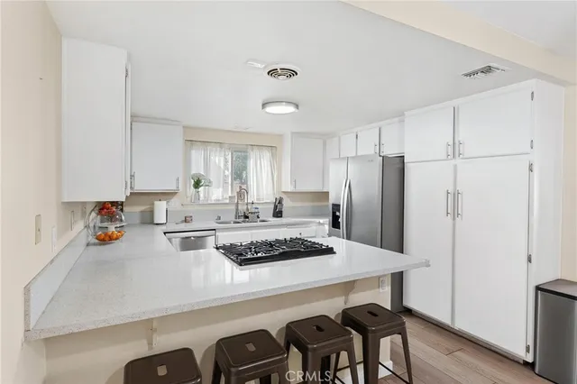 a kitchen with a refrigerator a stove a sink and cabinets