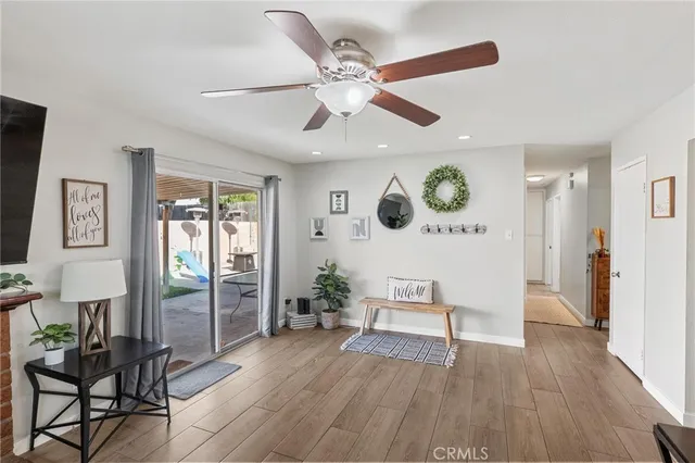 a view of a livingroom with furniture wooden floor and a ceiling fan