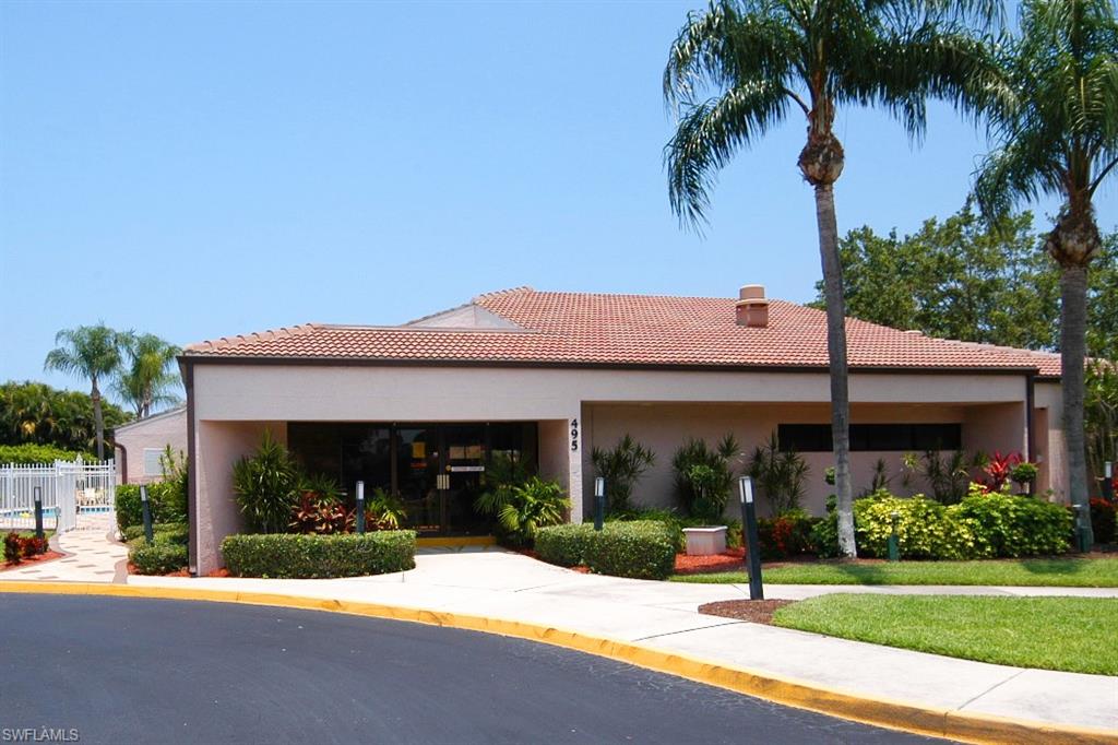 741 Landover Circle, Unit 203 Naples, FL 34104 - Photo 18 of 21 a view of a house with palm tree in front of it