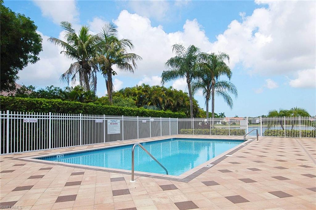 741 Landover Circle, Unit 203 Naples, FL 34104 - Photo 20 of 21 a view of a swimming pool with a lounge chair