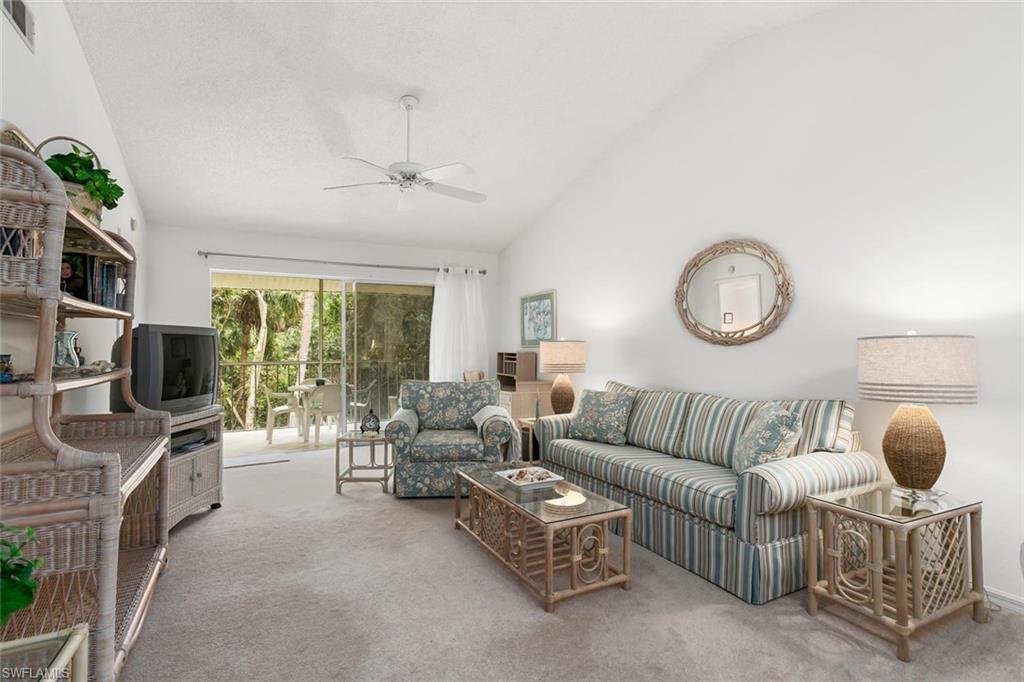 741 Landover Circle, Unit 203 Naples, FL 34104 - Photo 3 of 21 a living room with furniture a flat screen tv and a window