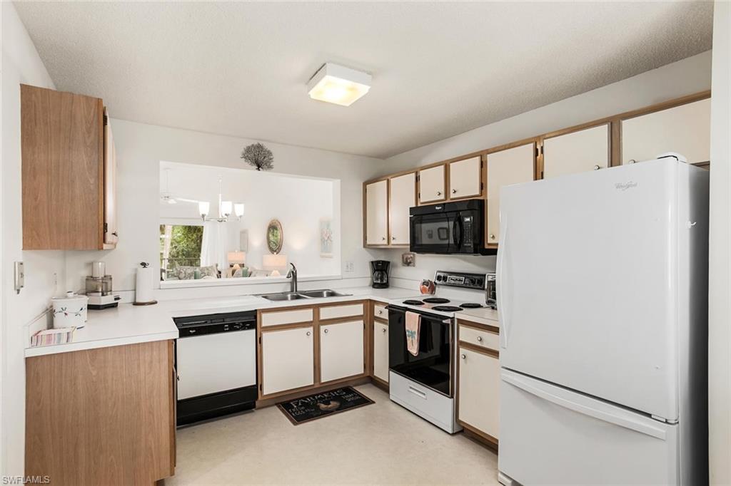 741 Landover Circle, Unit 203 Naples, FL 34104 - Photo 5 of 21 a kitchen with stainless steel appliances a stove a sink and a refrigerator
