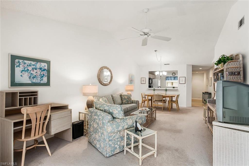 741 Landover Circle, Unit 203 Naples, FL 34104 - Photo 8 of 21 a living room with furniture a rug and white walls