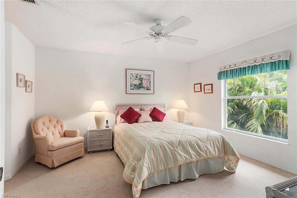 741 Landover Circle, Unit 203 Naples, FL 34104 - Photo 9 of 21 a bedroom with a bed and a couch