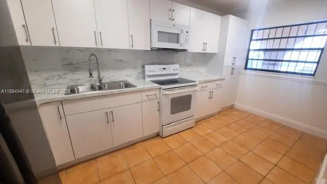 a kitchen with a sink cabinets and appliances