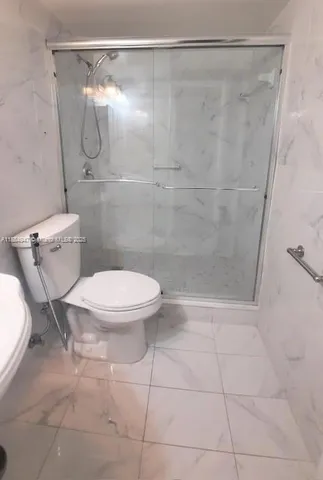a bathroom with a toilet and a shower